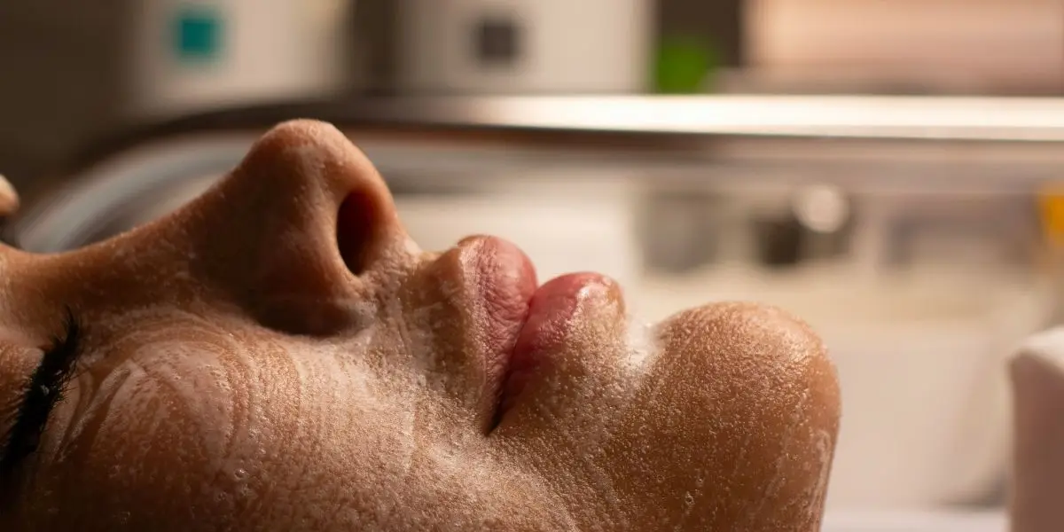 “Mulher recebendo tratamento facial hidratante em clínica estética, representando cuidados com a pele.”